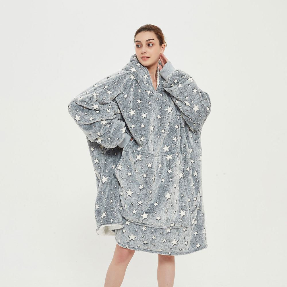 Snuggyz star glow-in-the-dark hoodie blanket draped over a sofa, showcasing its cozy, star-patterned design for comfortable lounging.